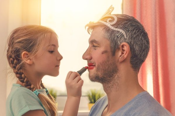 dad cute daughter being treated lipstick and wearing tiara