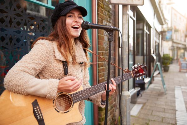 Female Musician Busking Playing Guitar Singing Street