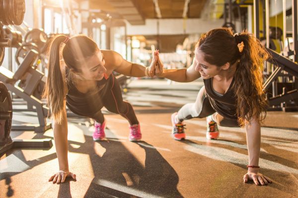 women high five working out at gym