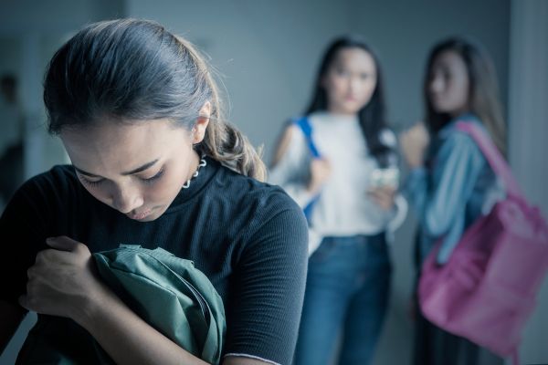 depressed teen girl verbally bullied by peers school