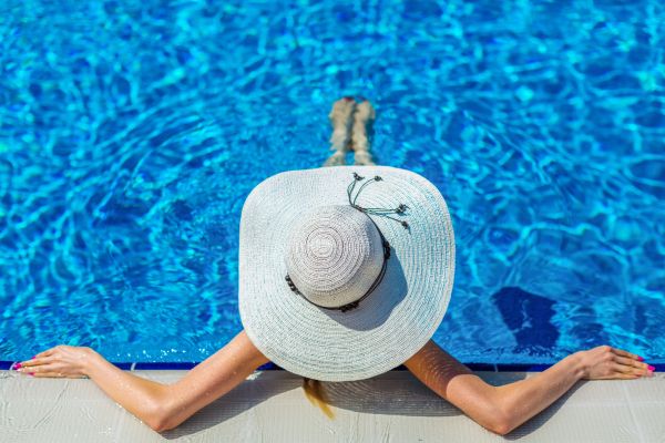 wearing beach hat sitting in pool relaxing enjoying sun