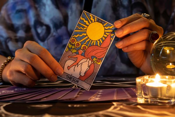 teller hands holding sun card tarot