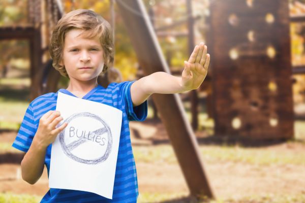 boy holding anti bullies sign stop gesture