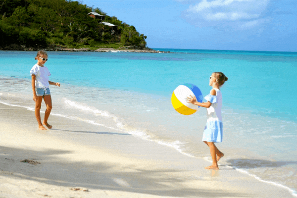 girls playing beach ball toss game on beach summer sea view