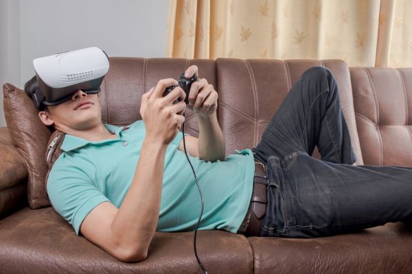 man wearing virtual reality goggles playing games