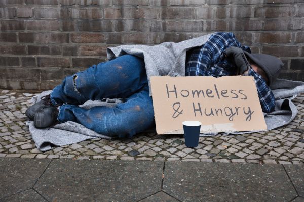 Male Beggar Lying On Street homeless and hungry cardboard