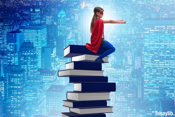 Superhero Little Girl red cape sit on pile of books city view background