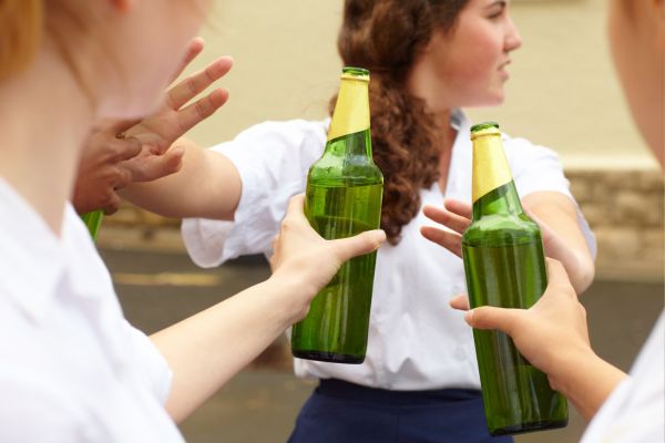 Young female student turning down alcohol peer pressure