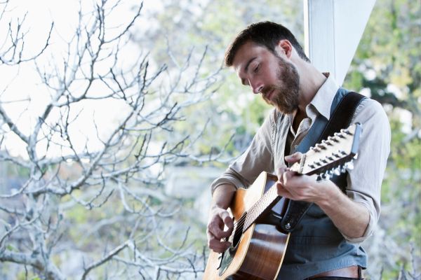 musician Playing Brown Acoustic Guitar composing sad song