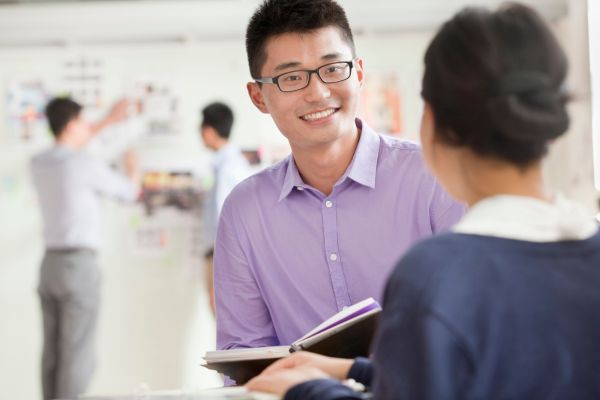 asian colleagues work talking smiling replying critics