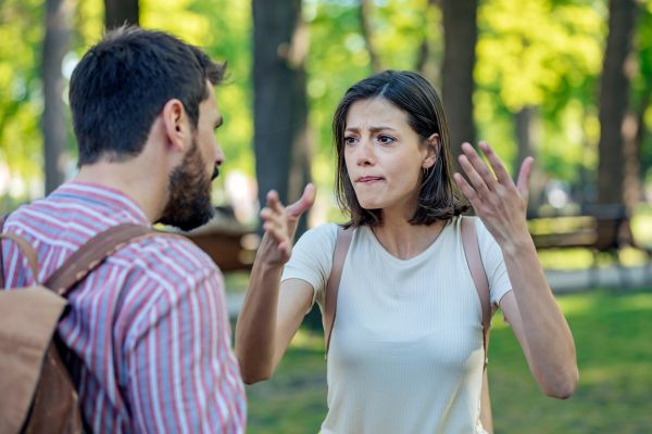 couple arguing on the park outdoor green trees embarrassing